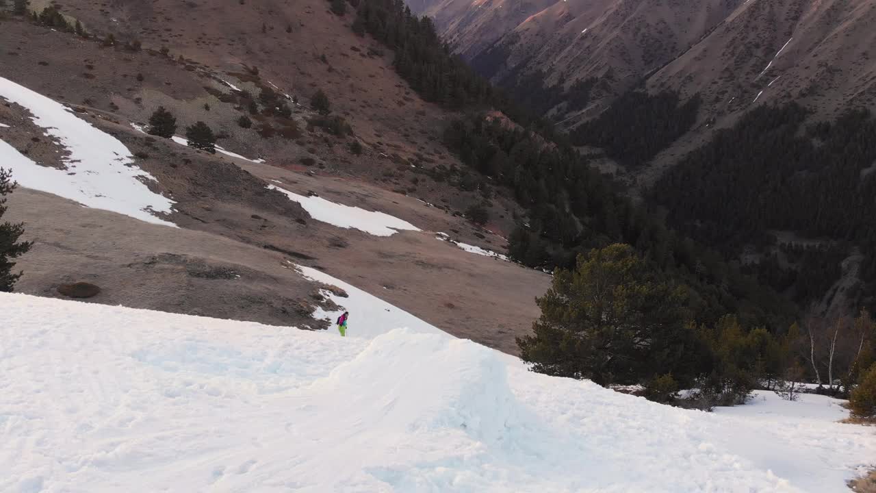 鸟瞰图女运动员公司在滑雪板和滑雪板上走下雪坡在春天。最后的自由骑行，穷乡僻岭视频素材