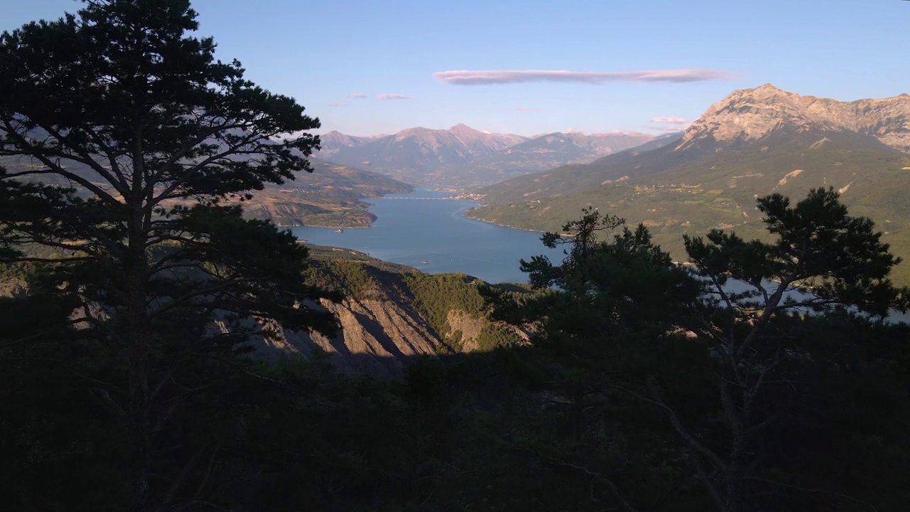 鸟瞰图通过树木接近Serre-Poncon湖与savaine -le- lac村和大摩根峰。杜兰斯山谷的夏天。上阿尔卑斯(阿尔卑斯山)，法国视频素材