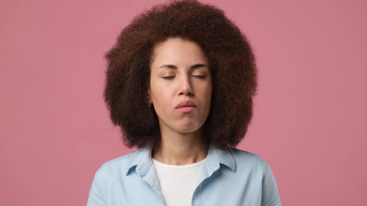 年轻的非洲裔美国妇女头痛和按摩太阳穴，以缓解疼痛孤立在粉红色的工作室背景视频素材