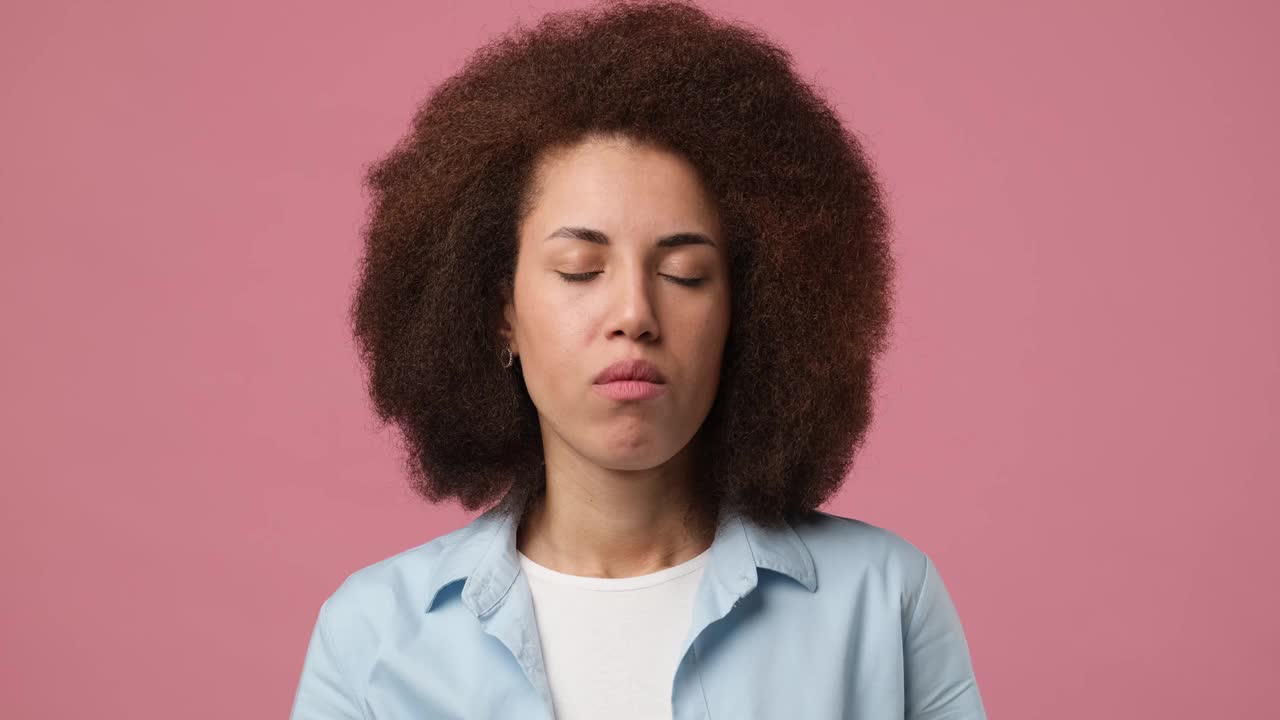 年轻的非洲裔美国妇女头痛和按摩太阳穴，以缓解疼痛孤立在粉红色的工作室背景视频素材