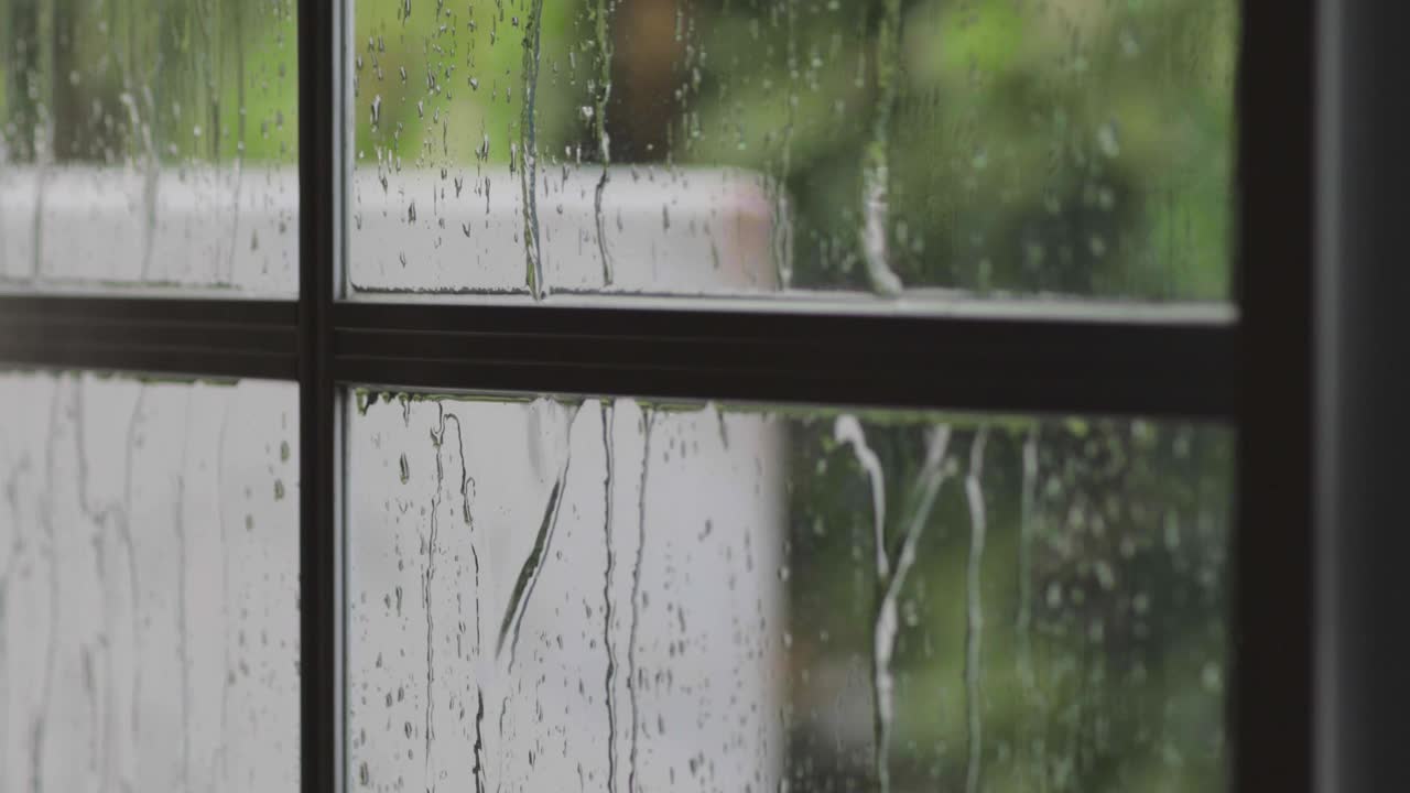 雨滴落在玻璃房子窗户上的特写视频素材