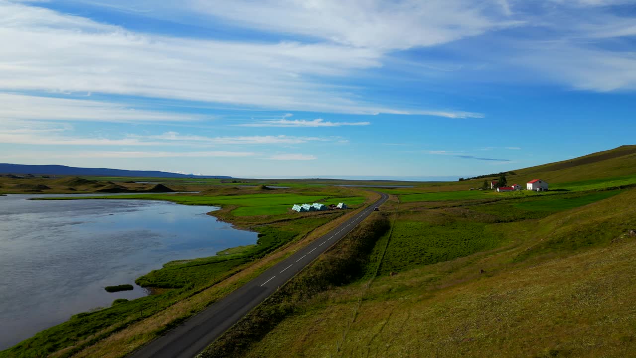 在冰岛的鲸鱼峡湾(Hvalfjorour)，无人机拍摄的水边道路和农村房屋视频素材