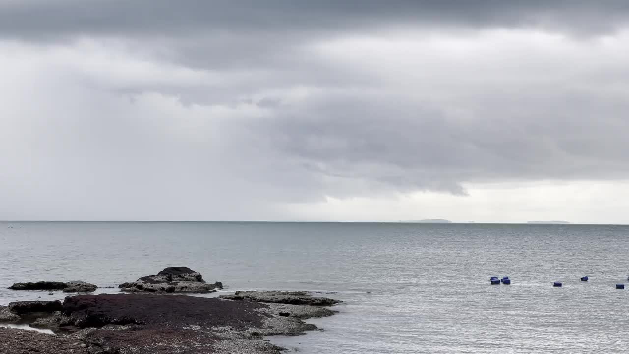 雨季热带海滩阴天前的天气。海浪冲击着沙滩。深灰色的风暴云。戏剧性的天空。视频素材