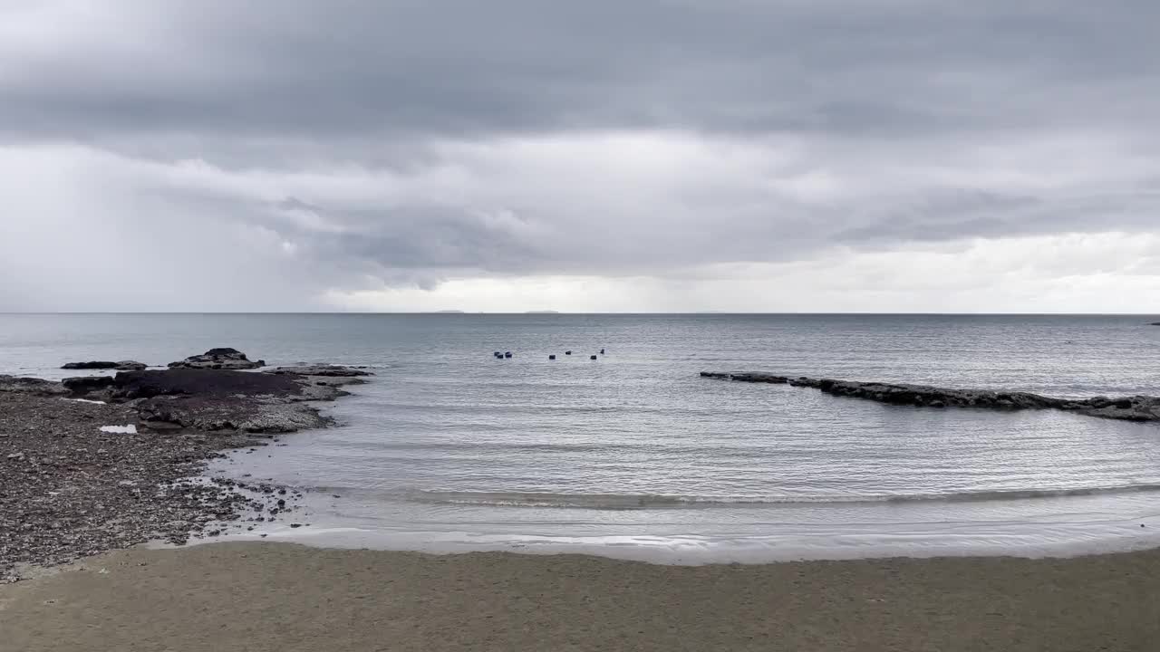 雨季热带海滩阴天前的天气。海浪冲击着沙滩。深灰色的风暴云。戏剧性的天空。视频素材