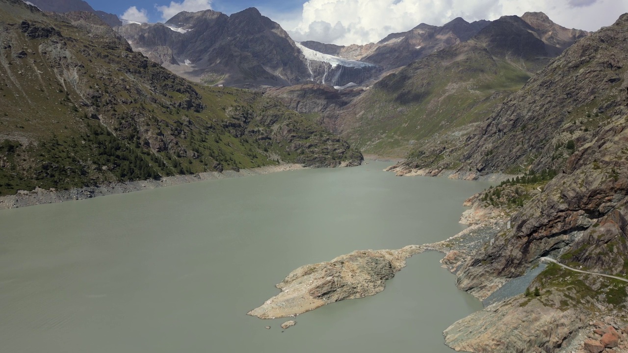 在Valmalenco山谷徒步旅行和在大自然中散步的无人机山路，意大利阿尔卑斯山，桑德里奥，意大利，由于干旱，Alpe Gera大坝半空的水-费拉里亚冰川融化视频素材