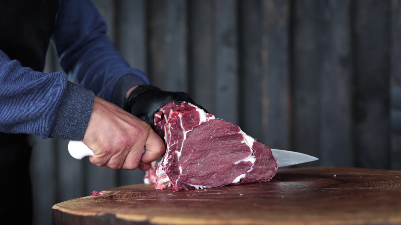 男农民手切大生肉片猪肉牛柳用刀质朴的木桩特写视频素材