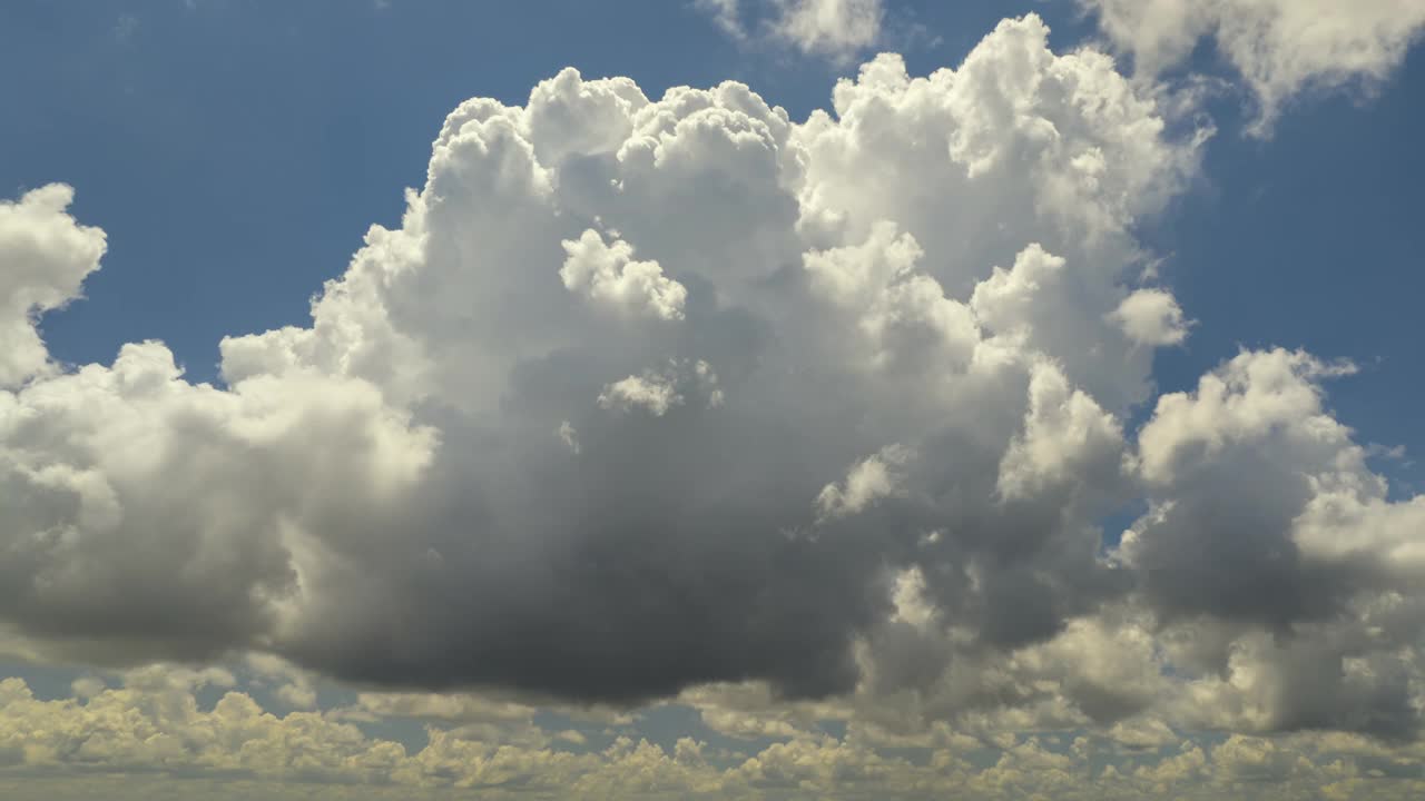 夏日蓝天上，雷暴前形成的白色蓬松积雨云。移动和变化的云景天气视频素材