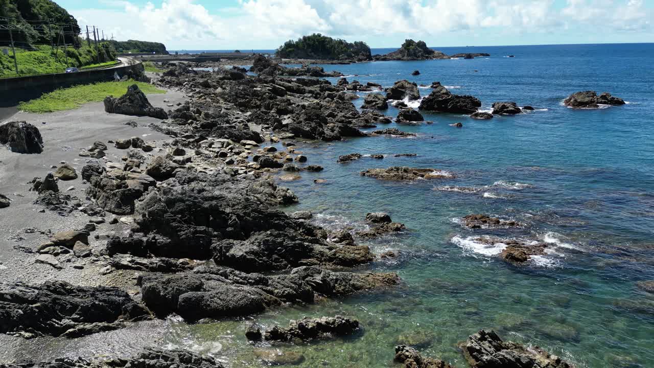 无人机拍摄的岩石海岸线，平静的海浪和多云的天空视频素材