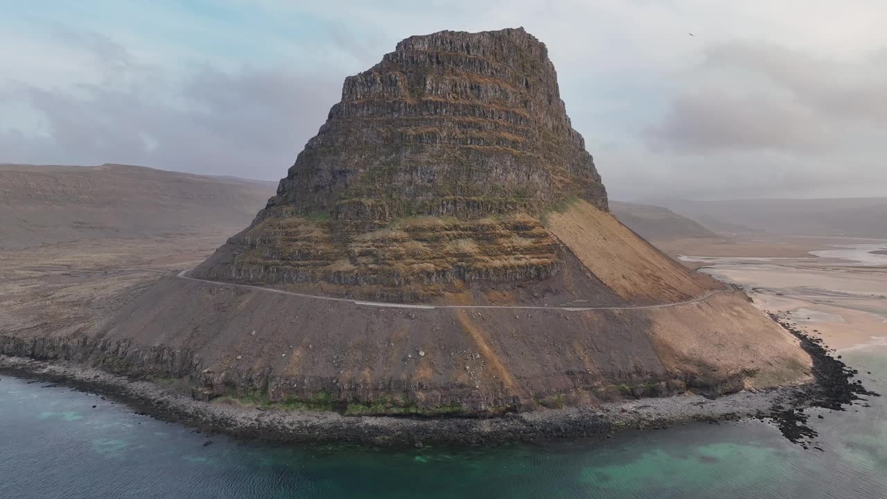 在冰岛西峡湾，在平静的蓝色海水和风景秀丽的山景中飞越patreksjordur。-空中回拉视频素材