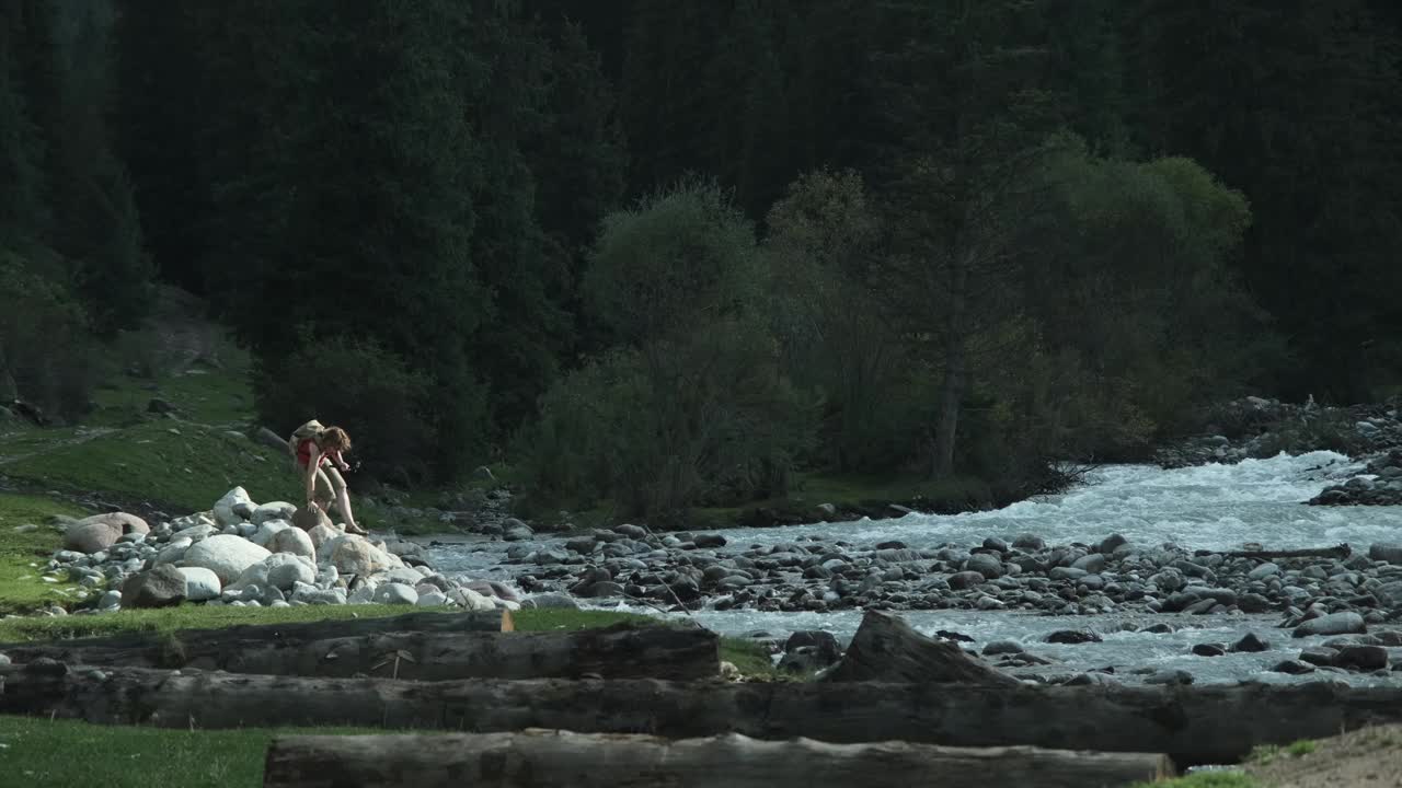 女游客在山河岸边徒步旅行并拍摄自己的视频视频素材