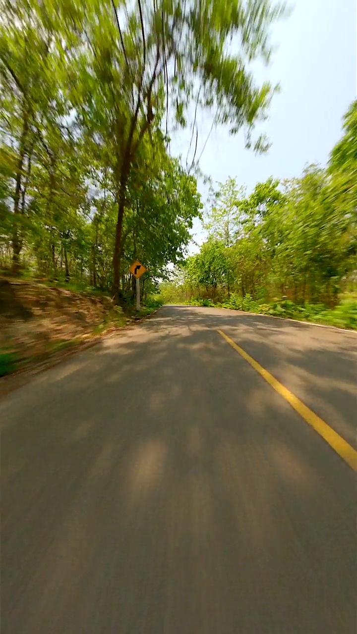 在夏季森林中央的公路上快速飞行。视频素材