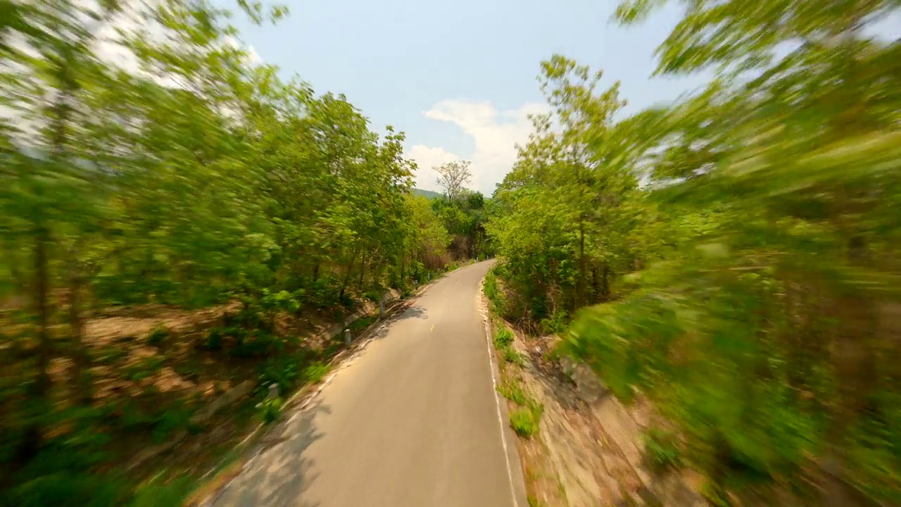 在夏季森林中央的公路上快速飞行。视频素材