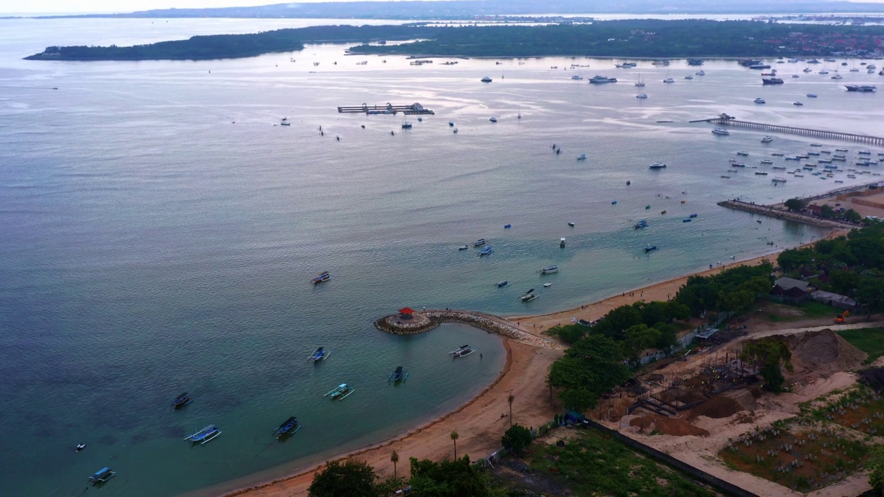 凉亭海滩度假酒店与Jukung渔船在Sanur，巴厘岛印度尼西亚。无人机航拍视频素材