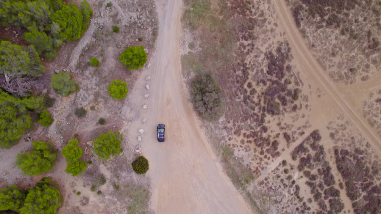 鸟瞰鸟瞰图跟随汽车穿过区域道路，穿过自然环境，干燥的景观，很少植被，越野驾驶概念，地点法国。视频素材