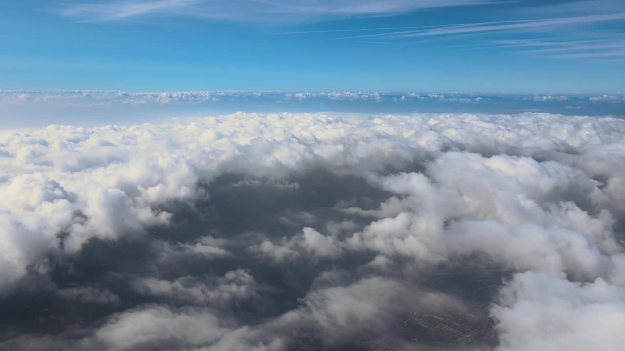 从高空的飞机窗口鸟瞰，暴雨前形成的蓬松的积云覆盖着地球视频素材