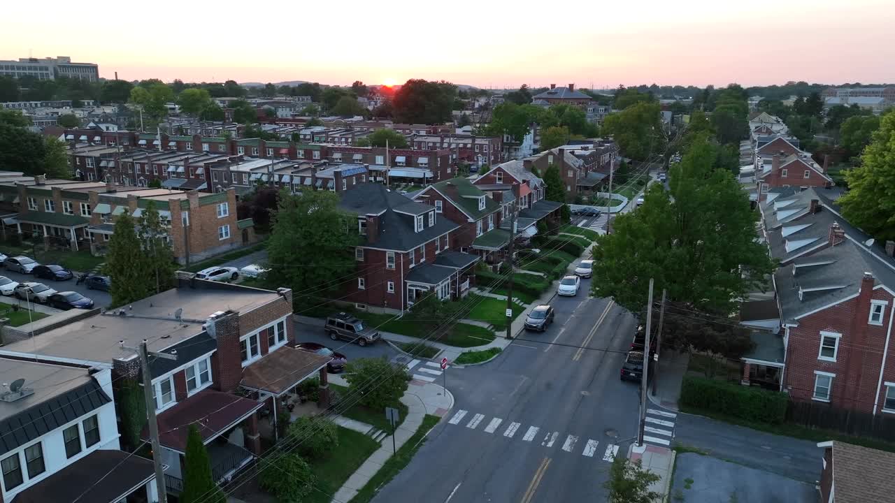 夏日夕阳下的美国城市。郊区主要街道上的房屋和住宅的航拍照片。视频素材