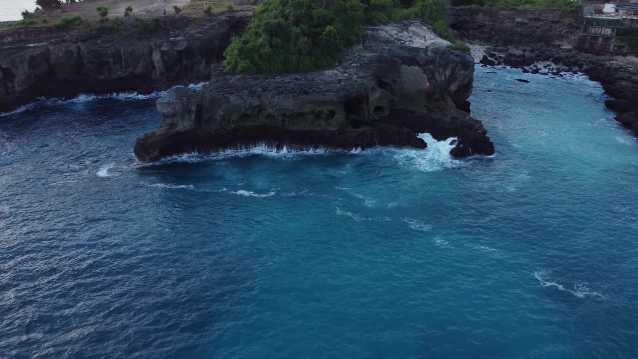 沿着海岸悬崖的蓝色泻湖与海浪从空中无人机，印度尼西亚。视频素材