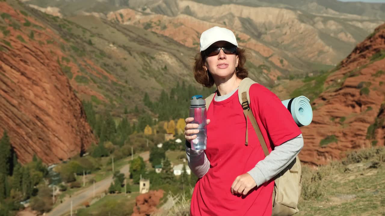 女游客站在山谷上喝水视频素材