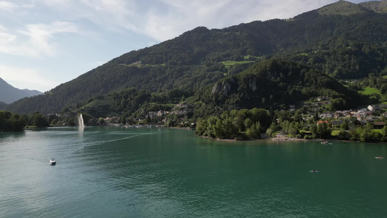 在瑞士的一个小山村附近，一艘船在蓝绿色的湖面上鸟瞰视频素材