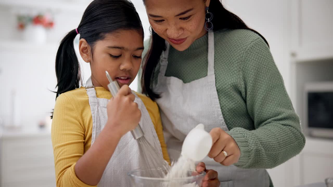 妈妈、孩子和快乐的在厨房里为爱、关心和学习甜点、食物或烹饪的食谱。女孩，母亲和帮助搅拌面粉原料，教和搅拌在家里的乐趣视频素材