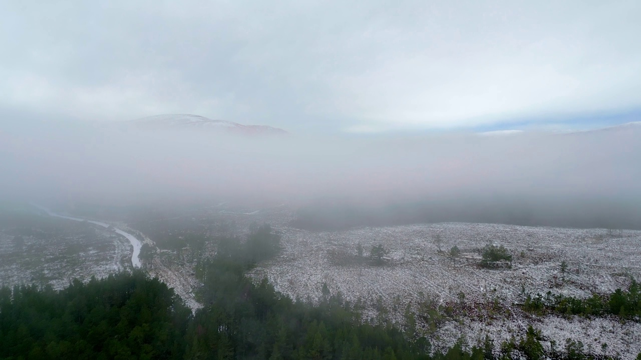 水面、岸边树木、雾中的冬季景观。积雪覆盖的高地的航拍画面。英国苏格兰视频素材