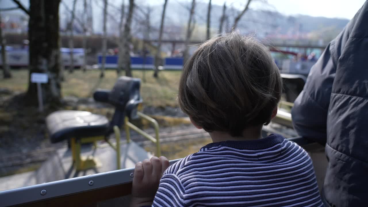 小男孩在瑞士蒸汽公园乘坐微型火车观赏风景视频素材