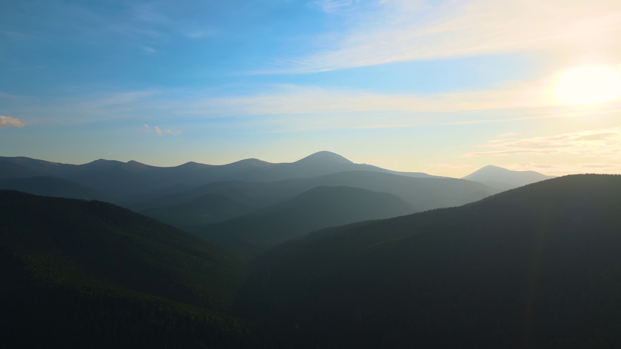 鸟瞰图，日落时，黑暗的山与明亮的夕阳。黄昏朦胧的山峰和朦胧的山谷视频素材