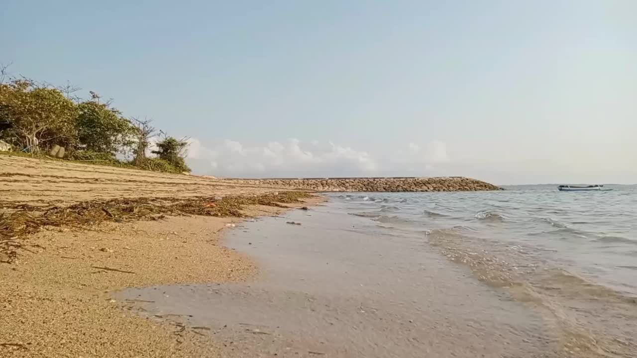 在峇里岛贝诺阿湾的海滩上，小浪撞击。视频下载