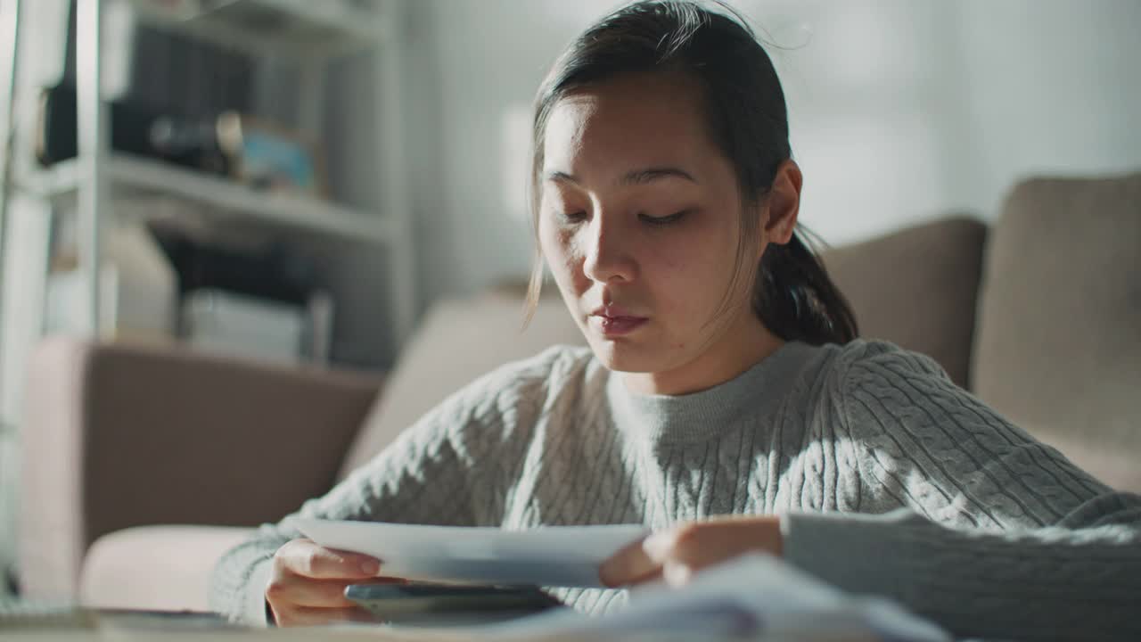 严肃的女人看着过期的债务账单视频素材