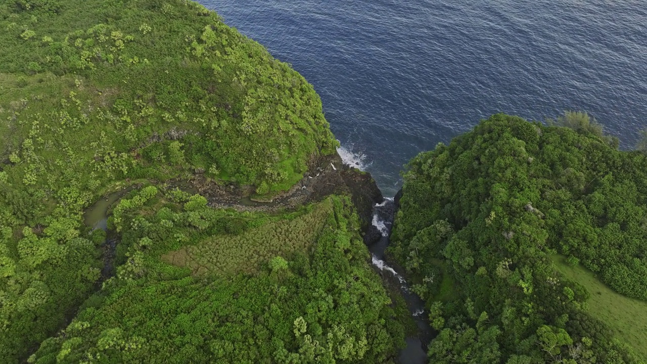 夏威夷毛伊岛航拍v35鸟瞰飞越奈利利利海勒和凯卢阿溪流，水流和瀑布从岩石悬崖进入海洋，在郁郁葱葱的植被中-拍摄与Mavic 3 Cine - 2022年12月视频素材