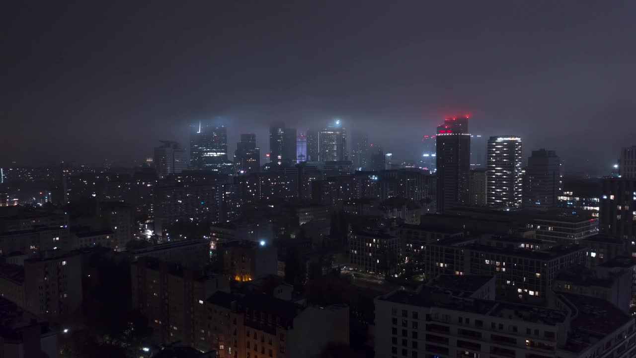 华沙市区天际线鸟瞰图在雾蒙蒙的秋夜。朋克的感觉。摩天大楼顶部的霓虹灯在雾中视频素材