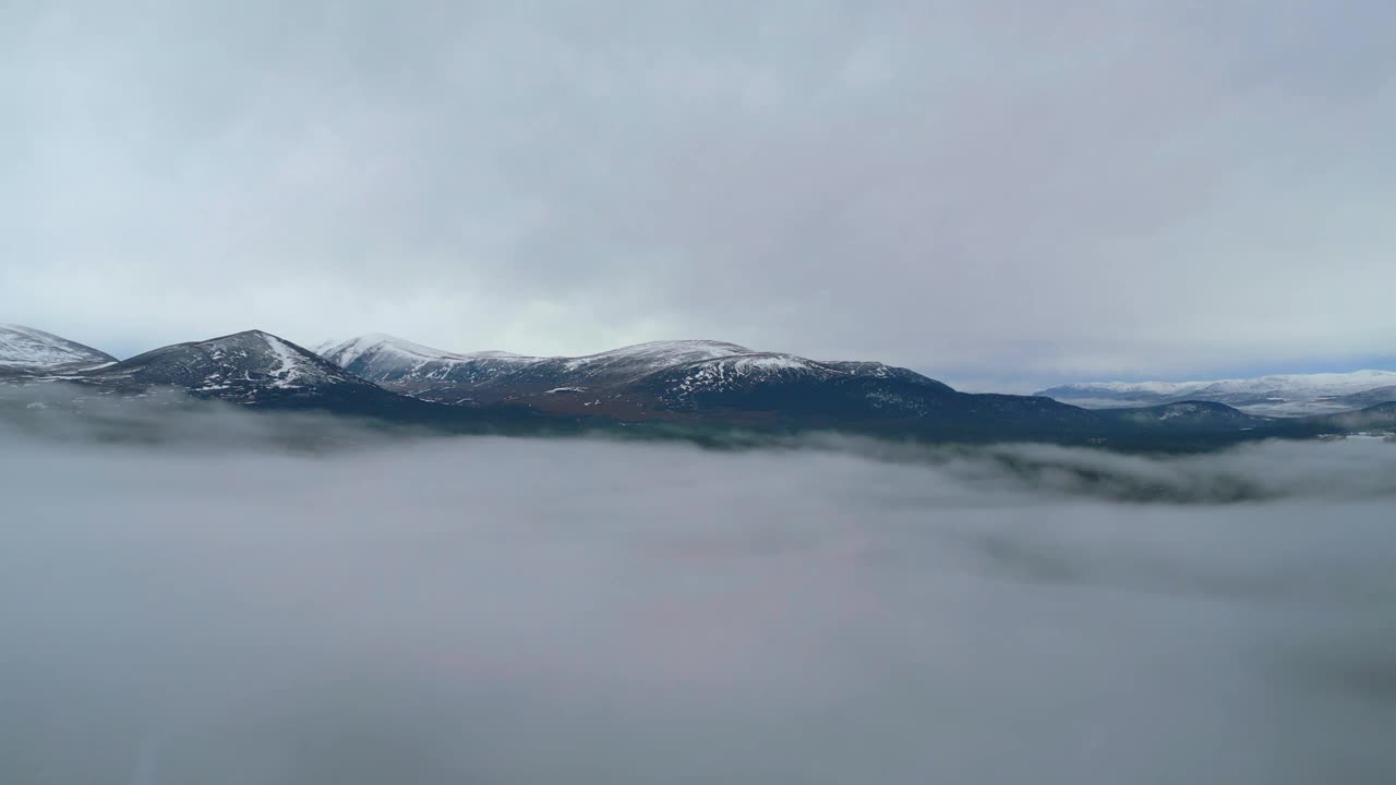 在薄雾中飞过白雪覆盖的乡村，飞向群山视频素材