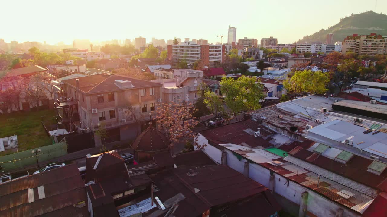 鸟瞰普罗维登西亚圣伊莎贝尔住宅区生锈的锡和锌屋顶，与智利圣地亚哥塞尔米尼城堡的建筑形成对比。视频素材