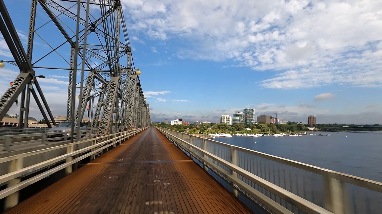 加拿大，城市天际线和河流背景的金属桥上的自行车道视频素材