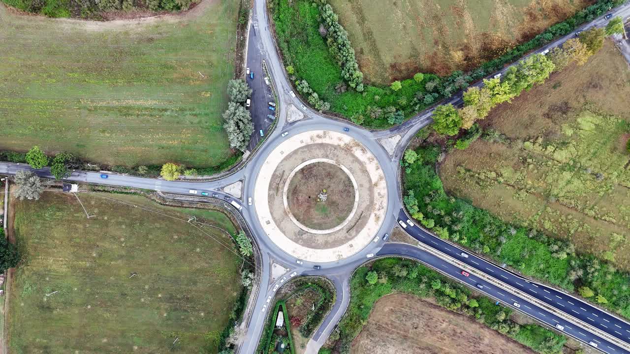 鸟瞰图的道路环岛交叉路口快速移动繁忙的交通。城市循环交通十字路口。视频素材