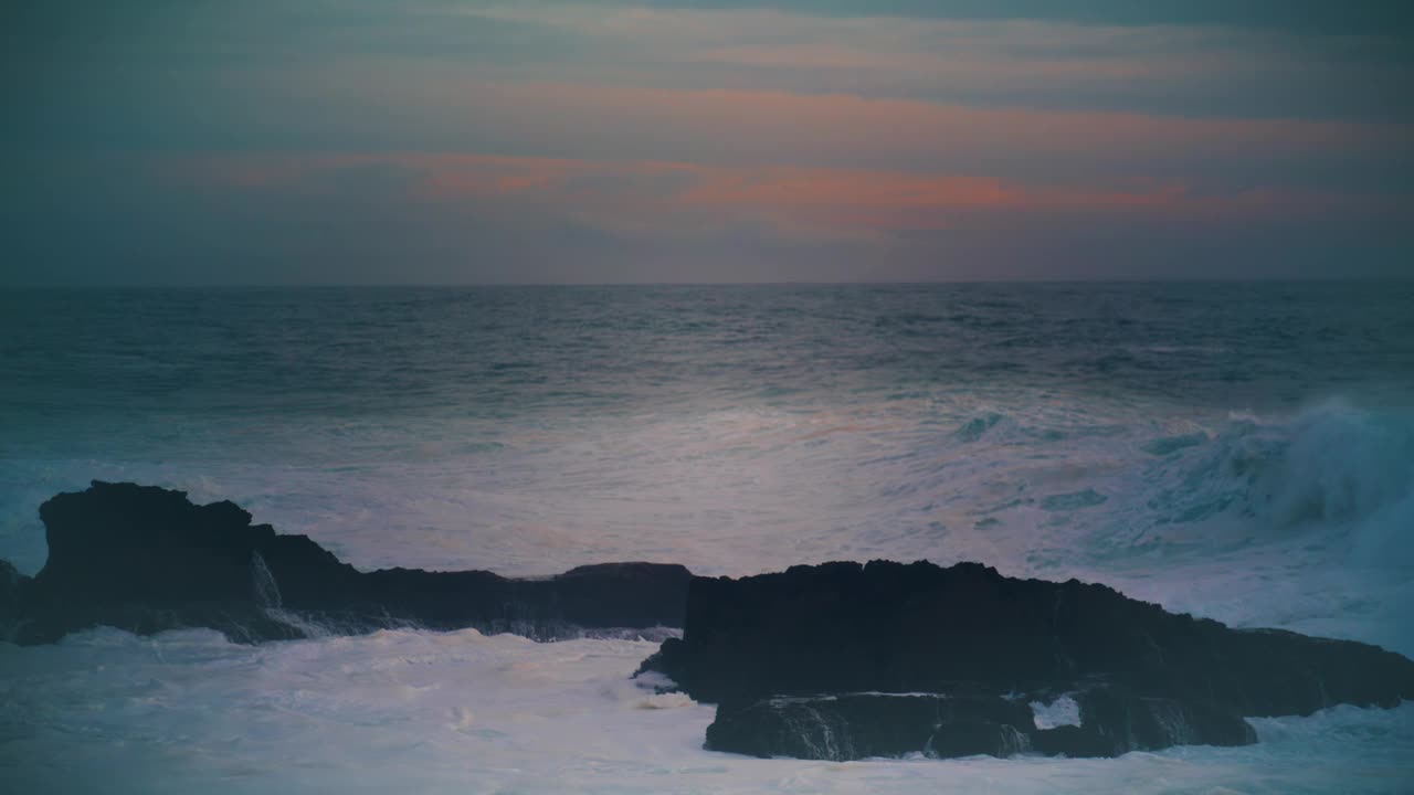 风暴海洋在黑暗的天际线上撞击海岸岩石。令人惊叹的黄昏海景视频素材