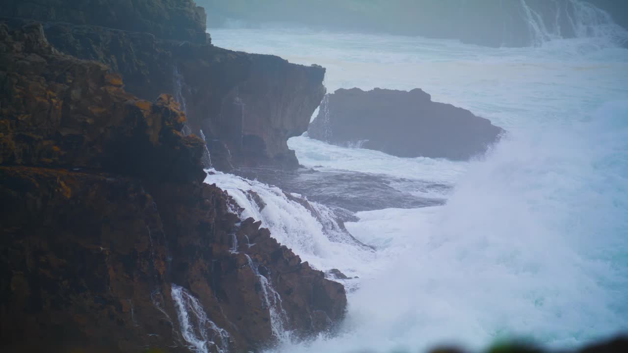 巨浪击碎悬崖，制造爆炸。特写:戏剧性的海洋冲刷视频素材