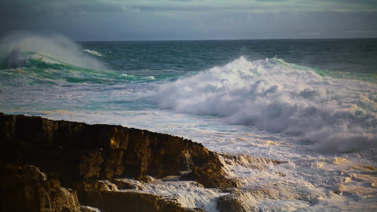 巨大的海浪在超级慢动作中打破岩石海滩。强大的海浪翻滚视频素材