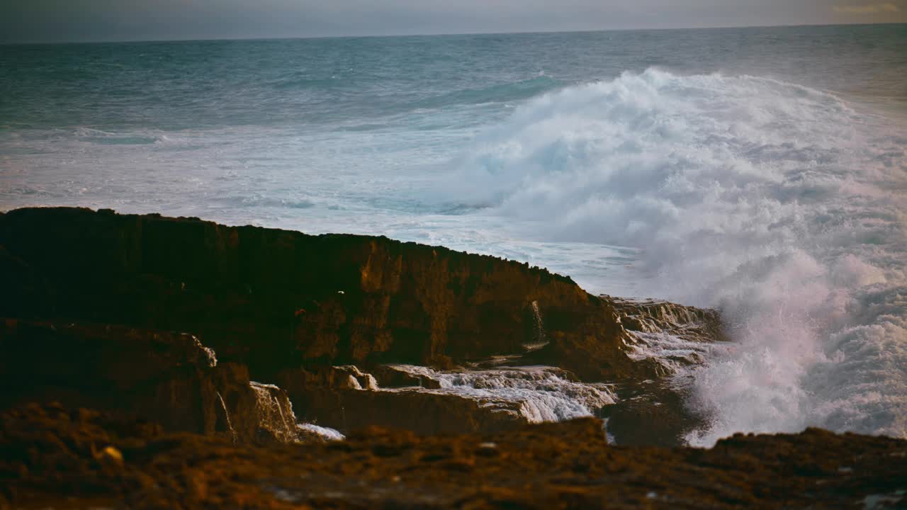 在暴风雨的日子里，海岸的海浪拍打着石头。强大的海浪冲击着海滩视频素材