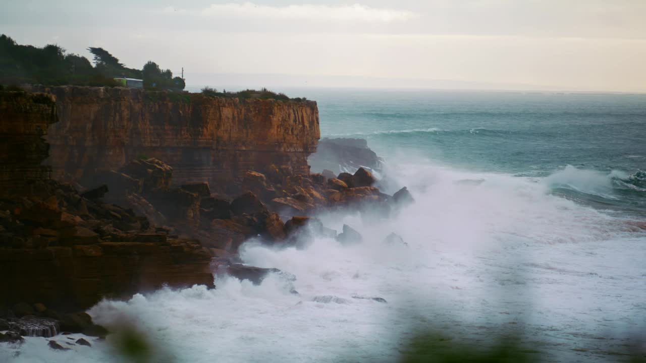 暴风雨的海洋在慢动作中打破悬崖。强大的海浪冲击着狂野的岩石视频素材