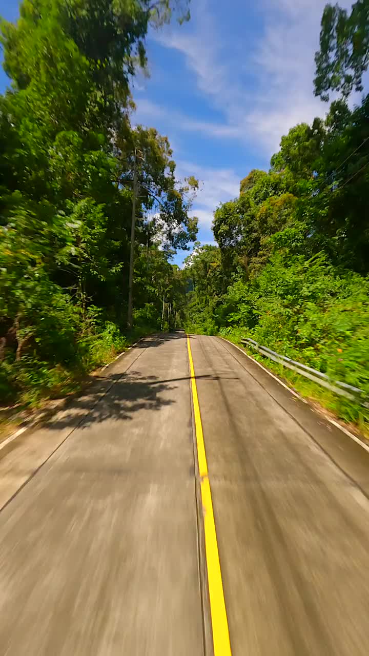 在泰国丛林中的热带公路上，FPV快速飞行视频素材