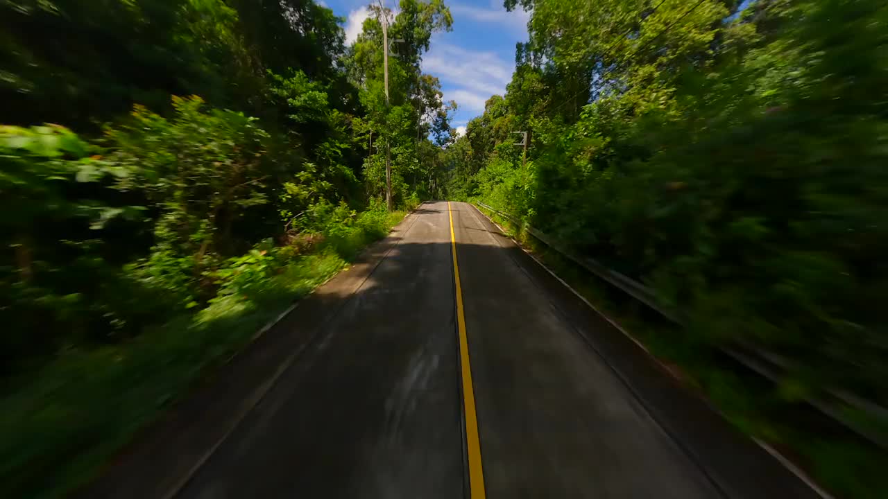 在泰国丛林中的热带公路上，FPV快速飞行视频素材