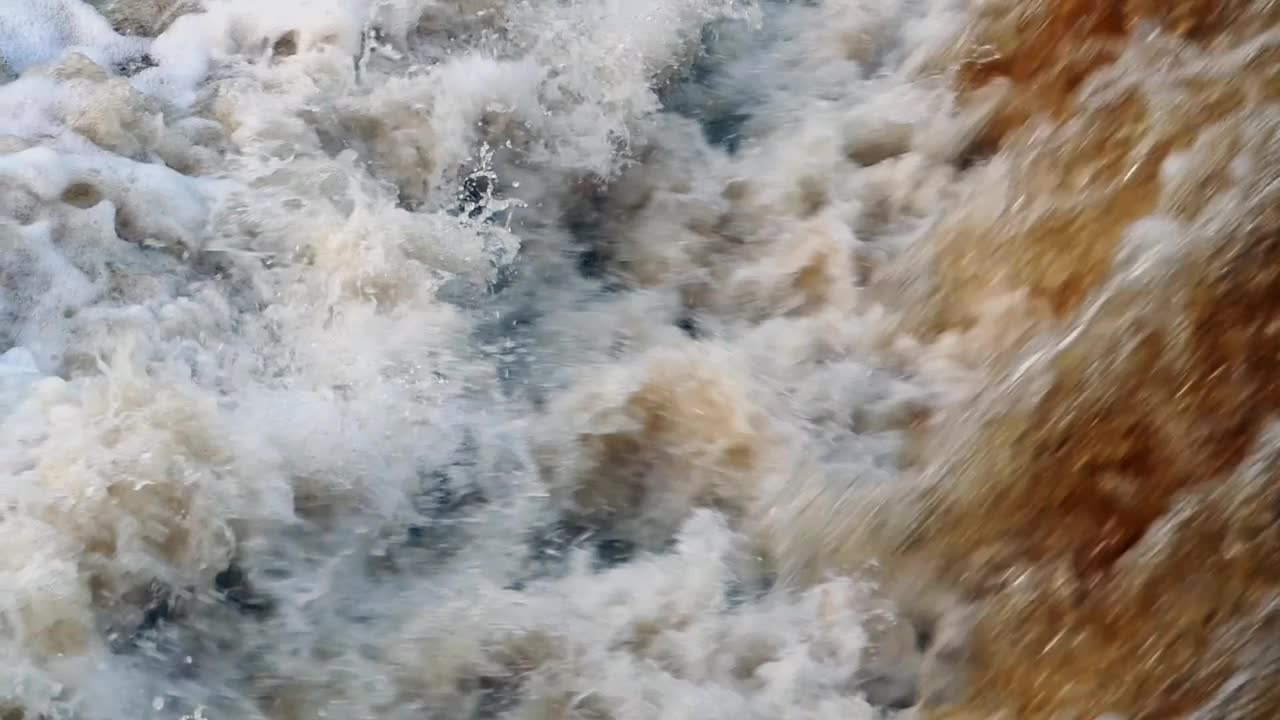 瀑布的慢动作，瀑布的脚下，水流破碎成数十亿个水花视频素材