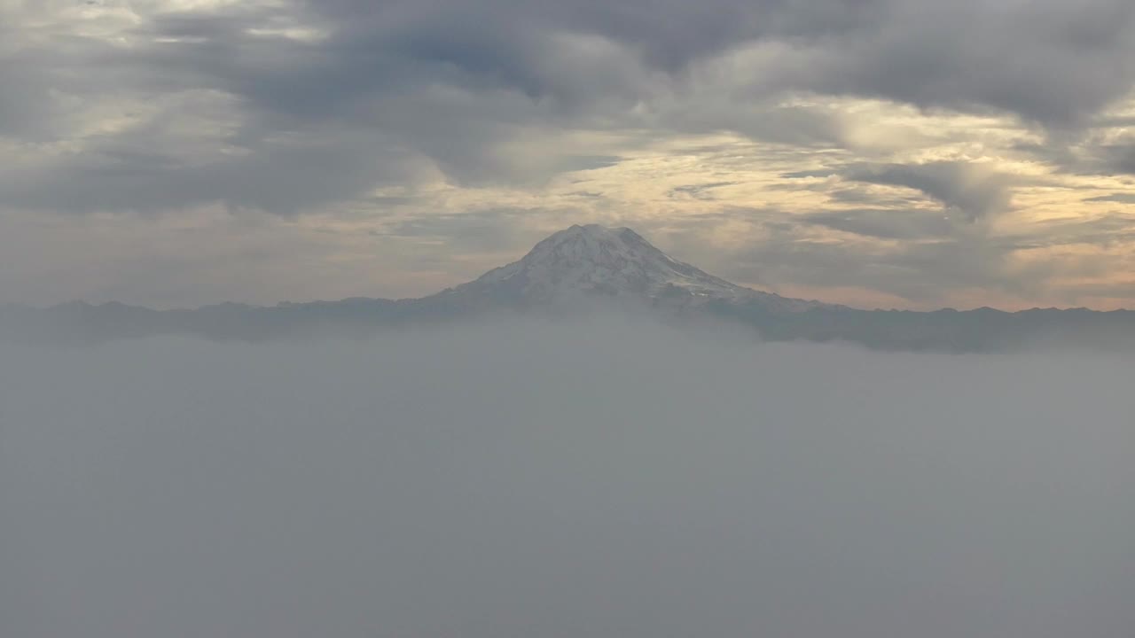 风景秀丽的雷尼尔山漂浮在日落时分的云景在华盛顿，美国。航拍广角视频素材