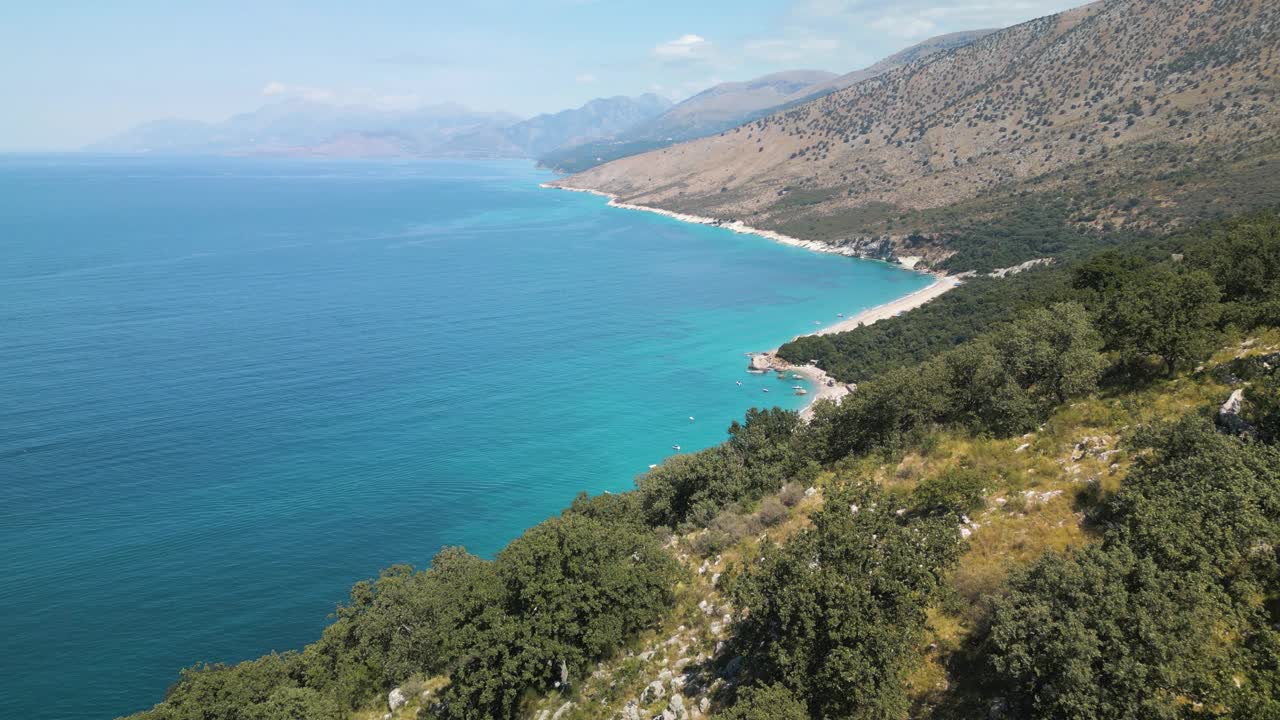 无人机小车推过去崎岖的山坡，揭示热带白沙派对海滩视频素材