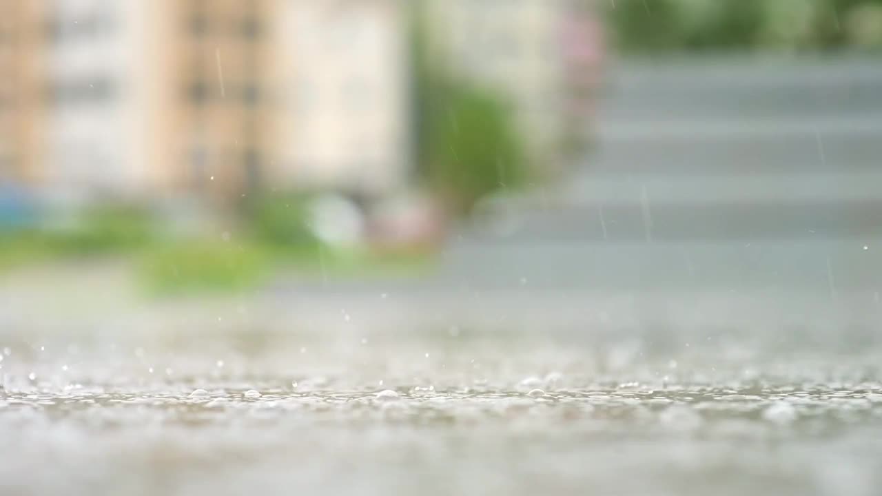 一个城市暴雨的大气视频。大雨和溅起的水坑从低点拍摄。视频素材