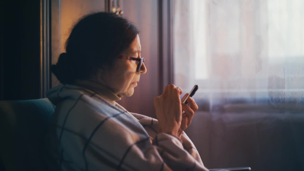 老年妇女翻阅智能手机，学习新技术视频素材