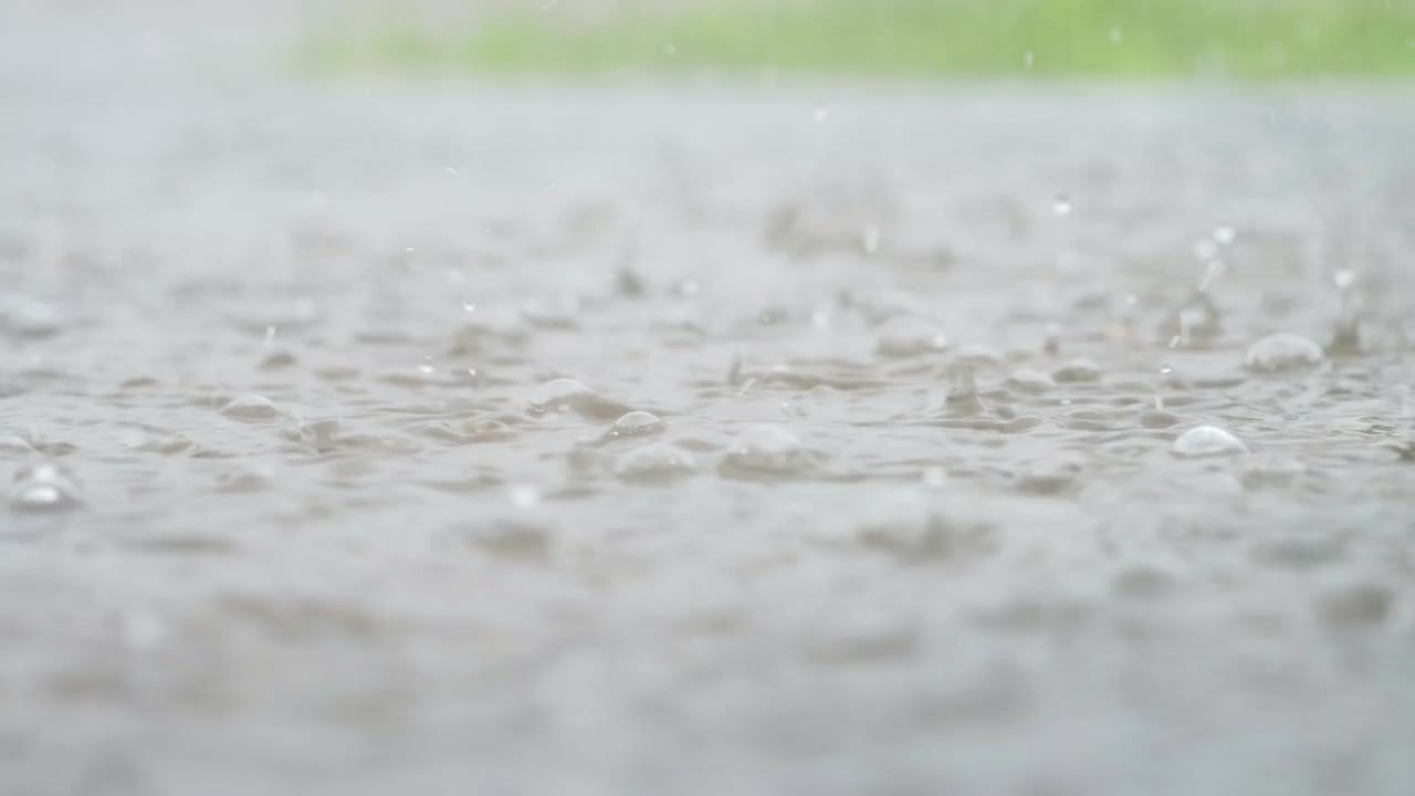 一个城市暴雨的大气视频。大雨和溅起的水坑从低点拍摄。视频素材