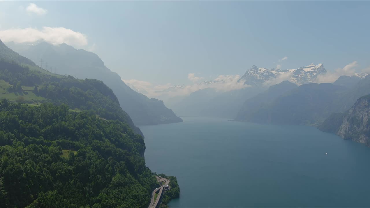 Morschach Flyover:移动在风景秀丽的水谷向阿尔卑斯山山脉，瑞士，欧洲，无人机|缓慢移动靠近悬崖边向山的风景公路视频素材