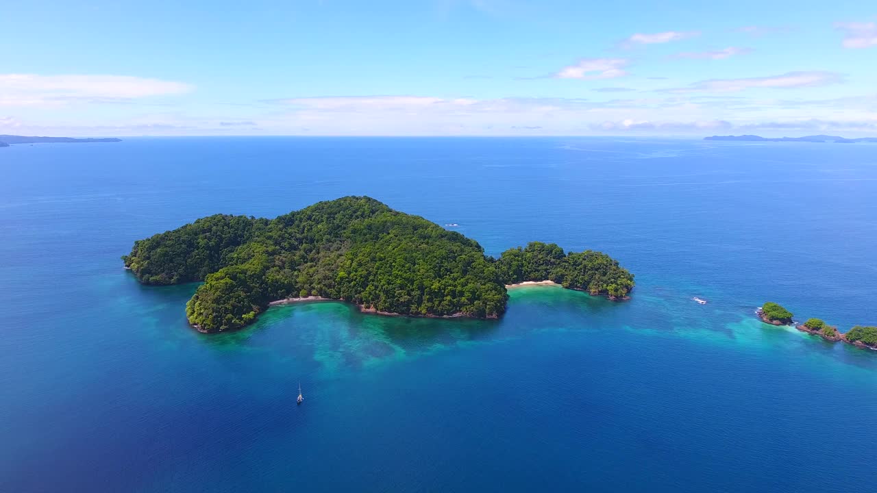 航拍镜头飞向一个被蓝色海水包围的偏远岛屿，这是巴拿马海上平静的一天视频素材